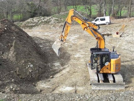 Excavatrice qui réalise le terrassement pour fondations de maison